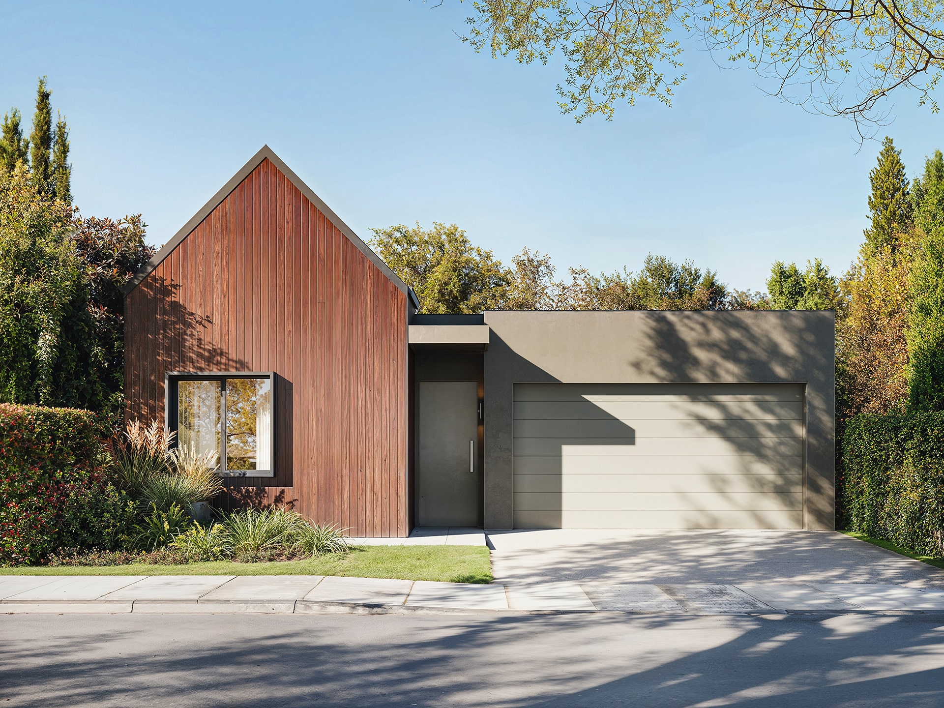 KBC: compact house facade with a timber gable and grey garage door